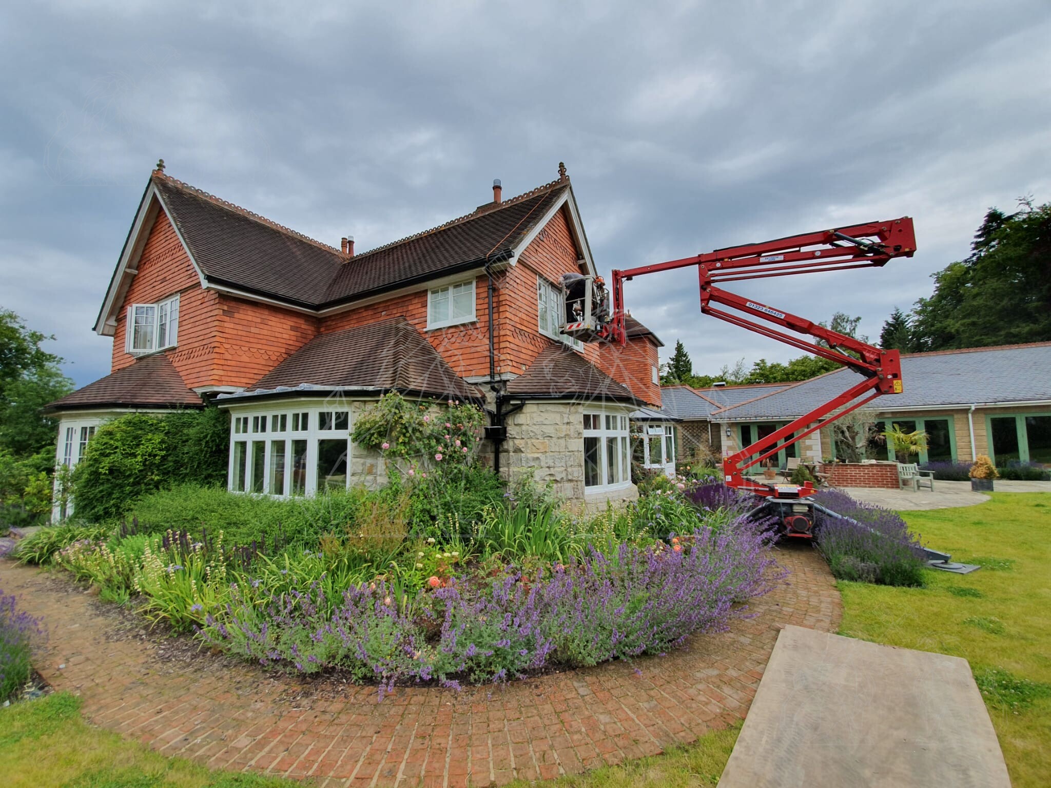 MEWP in use for high-level exterior maintenance at a large residence